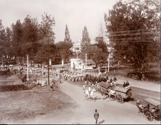 Parade melewati perlintasan kereta api Pasar Besar sekitar tahun 1910